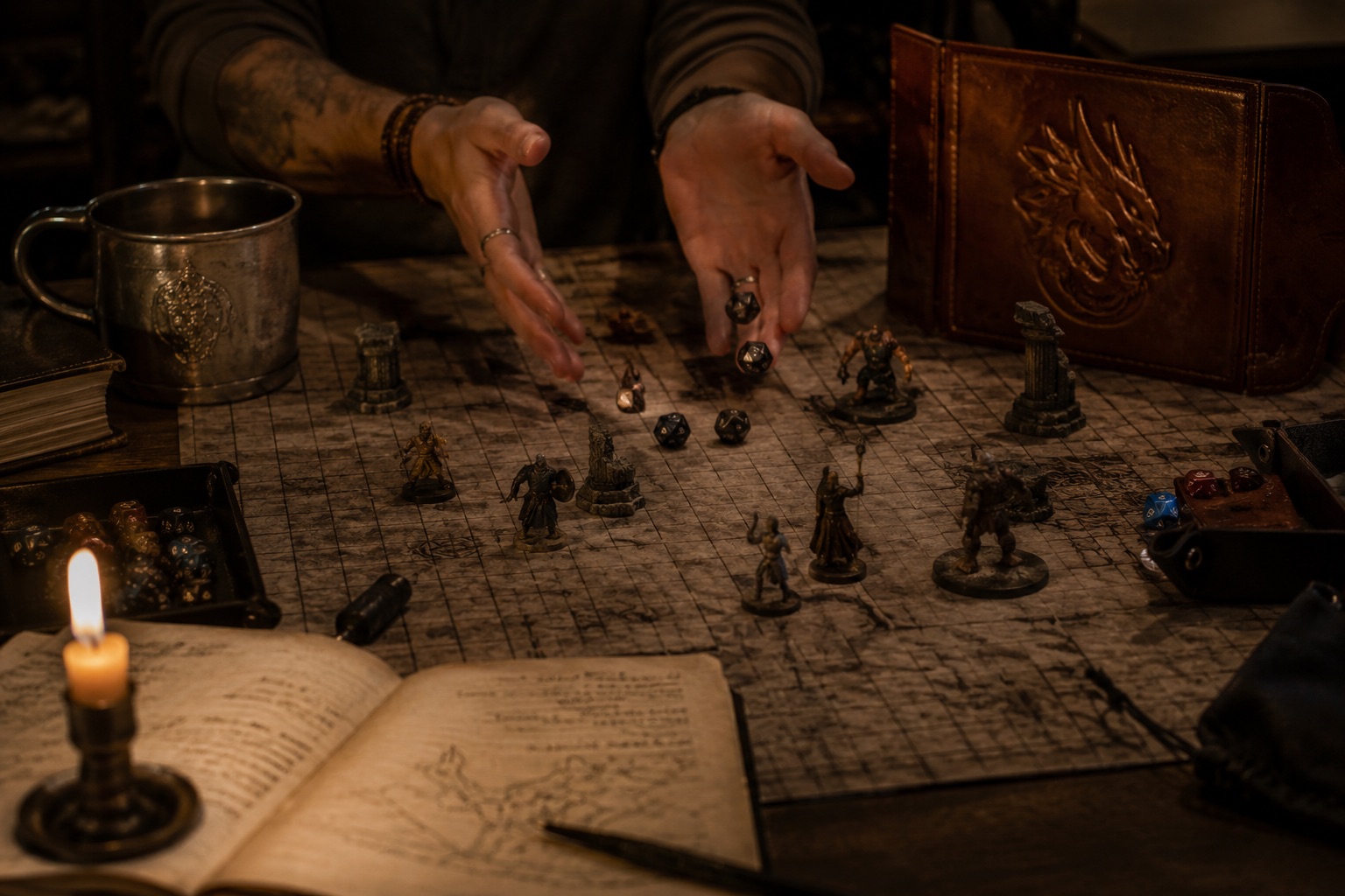 A D&D session in progress — dice, miniatures and a battle map by candlelight